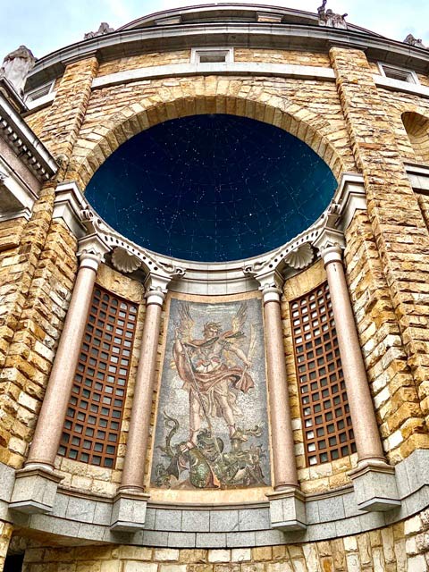 Detalle exterior de un ángel ensartando a un demonio en la iglesia de la Laboral de Gijón