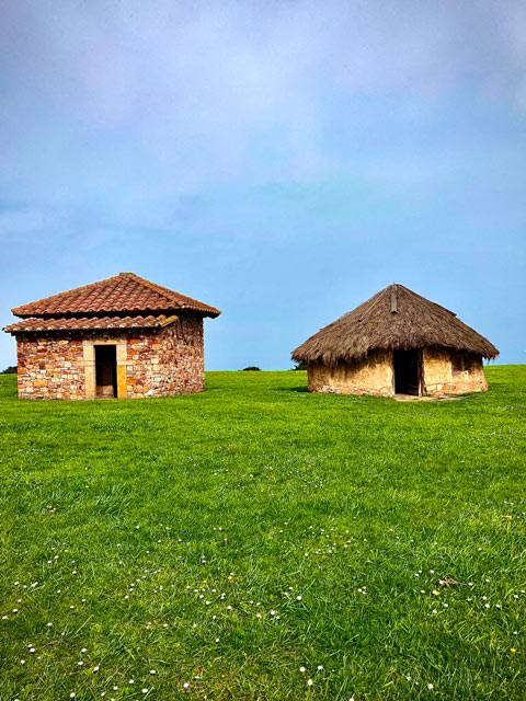 casa circular astur frente a casa cuadrangular romana en el Parque Arqueológico de la Campa Torres