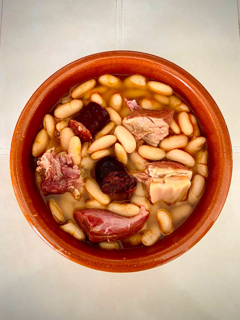 Fabada asturiana presentada en plato típico de barro