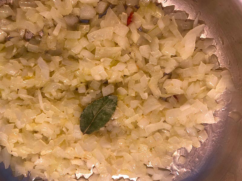 Pochando cebolla para cocinar llámpares a la sidra