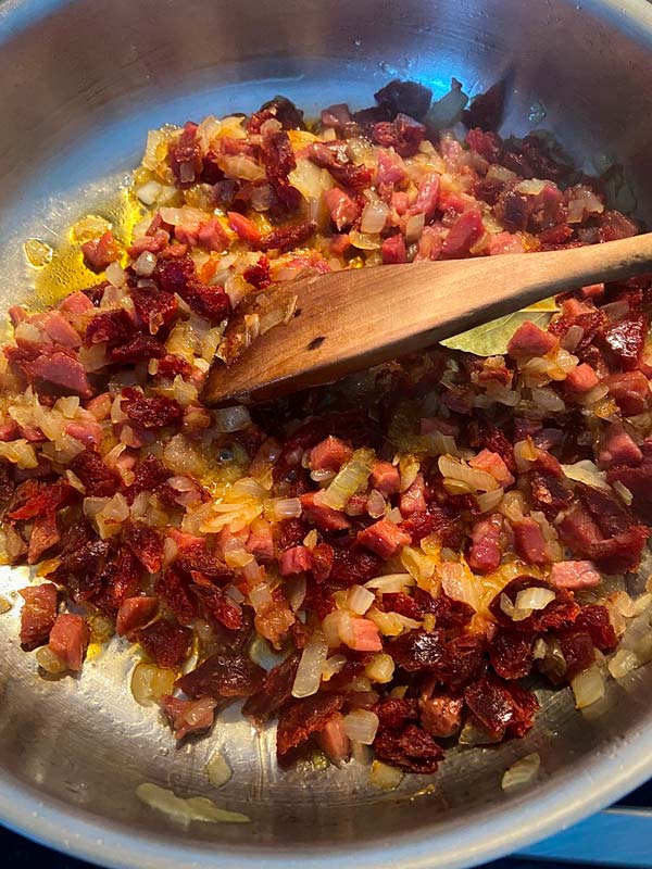Pochando cebolla con jamón y chorizo para cocinar llámpares a la sidra
