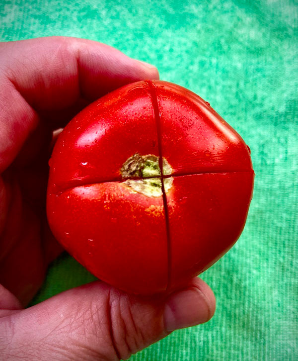 cortes realizados al tomate para ayudar a pelarlo parta la empanada de bocartes