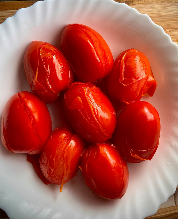 Tomates escaldados listos para pelar y echar a la empanada de bocartes
