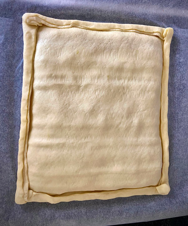 cerrando una masa sobre otra con el relleno dentro para la empanada de bocartes