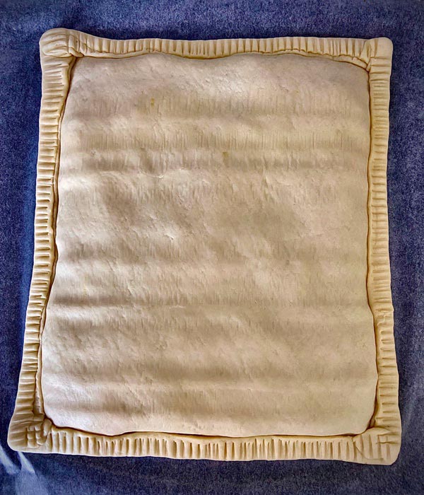 Aplastando el borde de la masa de la empanada de bocartes