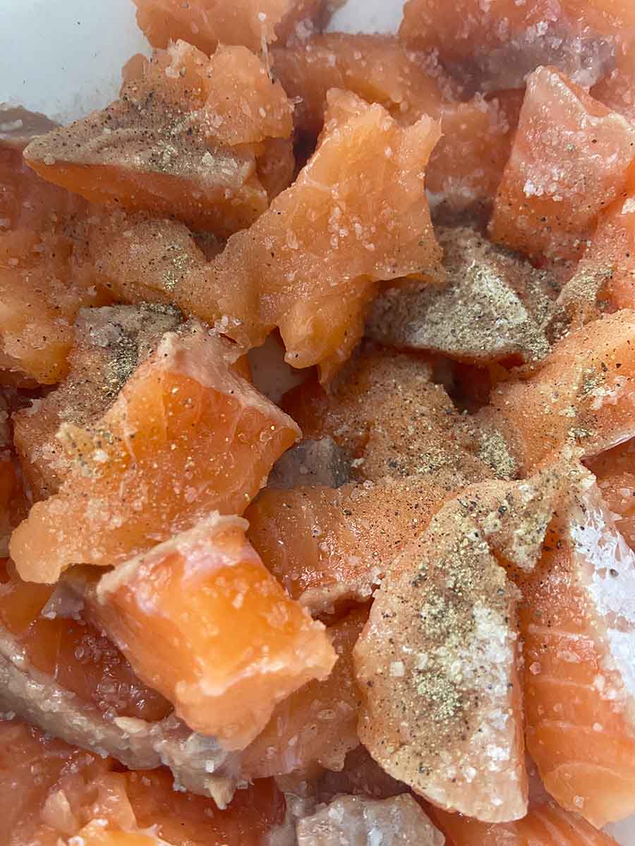Salmón troceado, salado y con pimienta blanca para pastel de cabracho