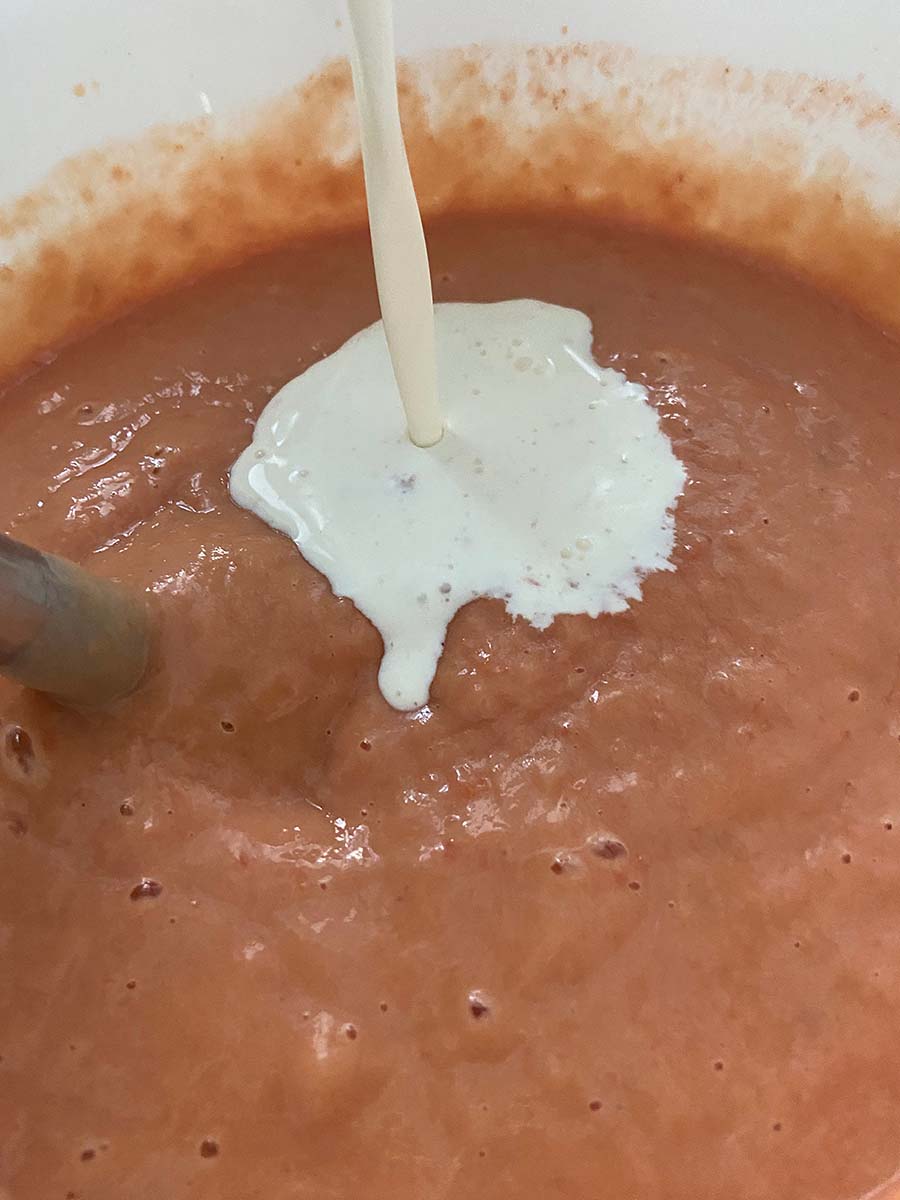 Añadiendo la nata líquida a la mezcla para pastel de cabracho