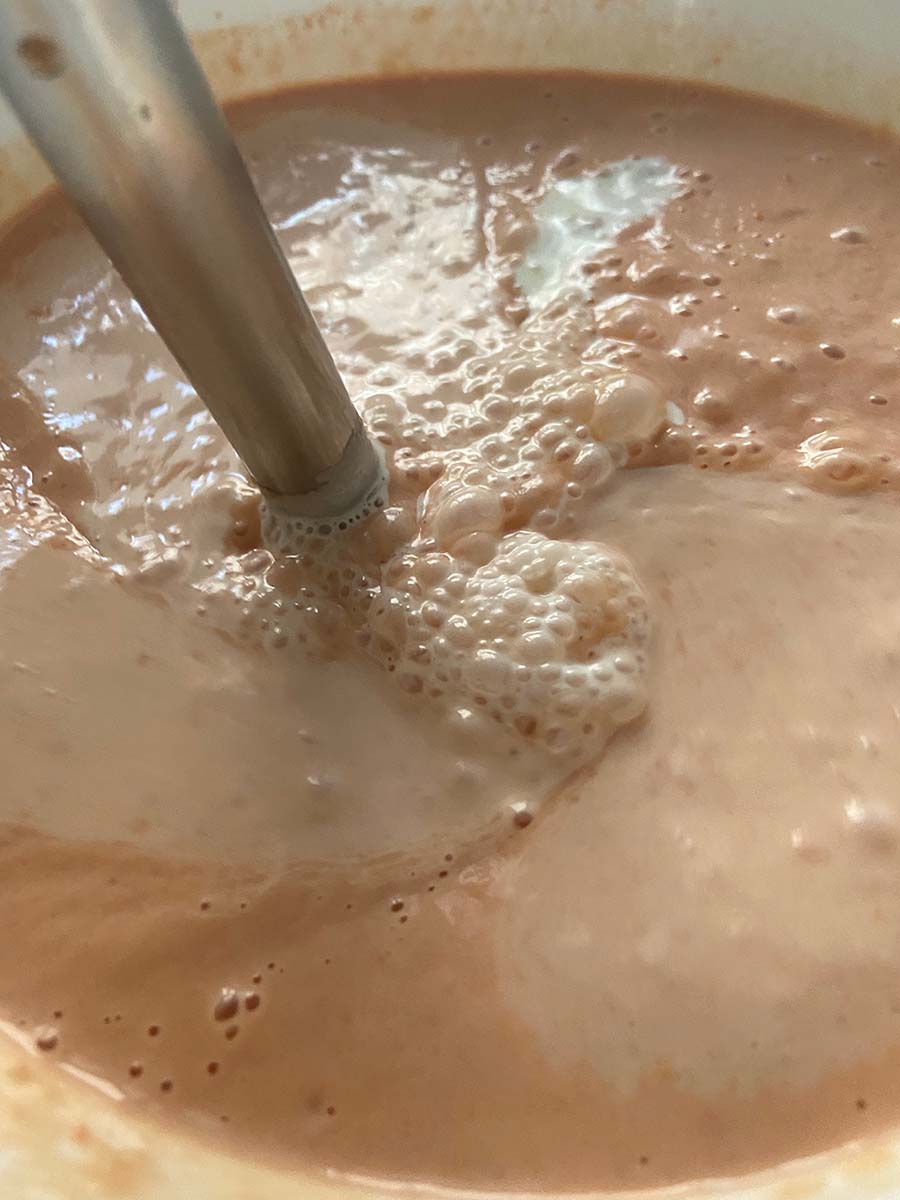 Añadiendo la nata líquida a la mezcla para pastel de cabracho