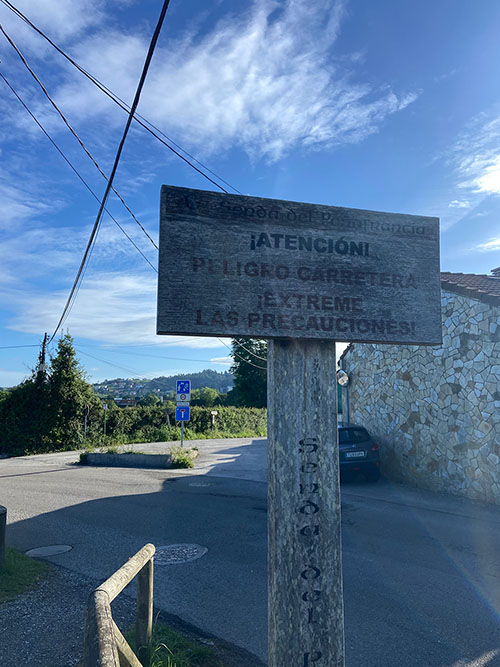 Señal de precaución en la carretera de Santurio en la senda del río Peñafrancia en Gijón.