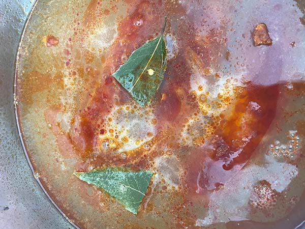 Echando el laurel y la cayena a los chorizos a la sidra