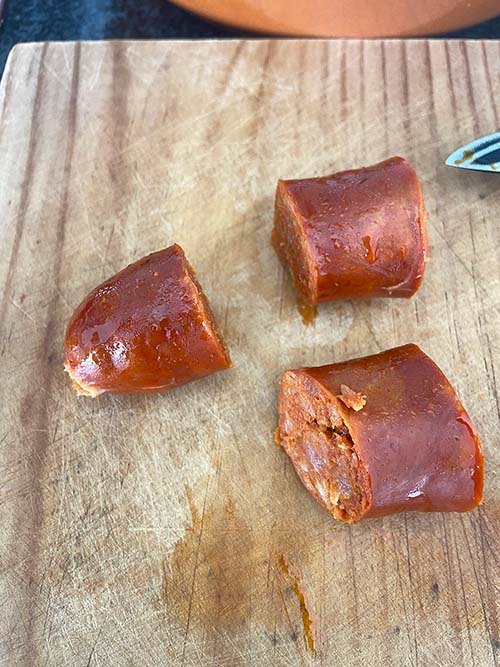 Troceando los chorizos una vez cocidos en sidra