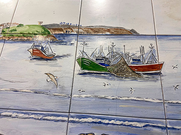 Mural que representa a los pecadores de Cimadevilla en Gijón recogiendo sus aparejos