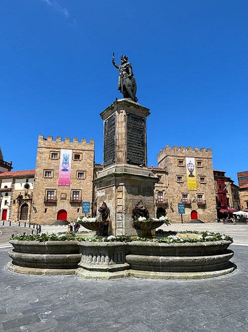 La fuente de la estatua de Pelayo en Gijón engalanada con flores para san Juan