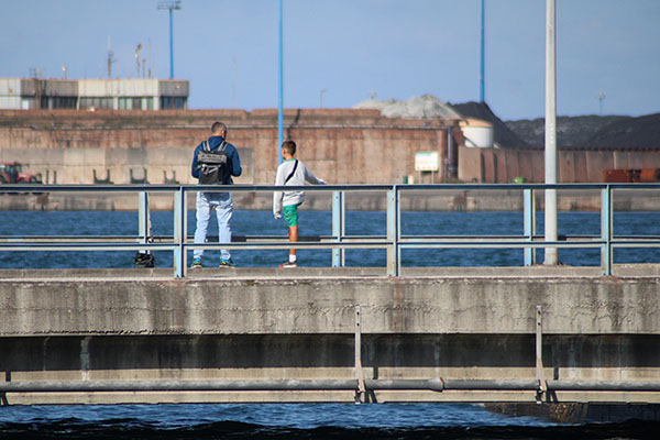 Niño pescando con su padre en el puerto del Musel en Gijón