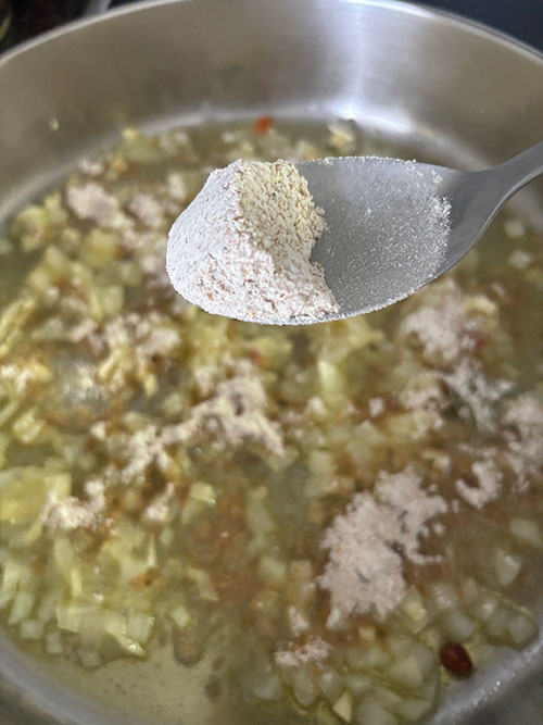 Añadiendo la harina al pochado para la salsa verde