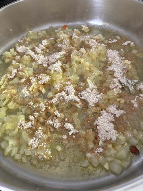 Añadiendo la harina al pochado para la salsa verde