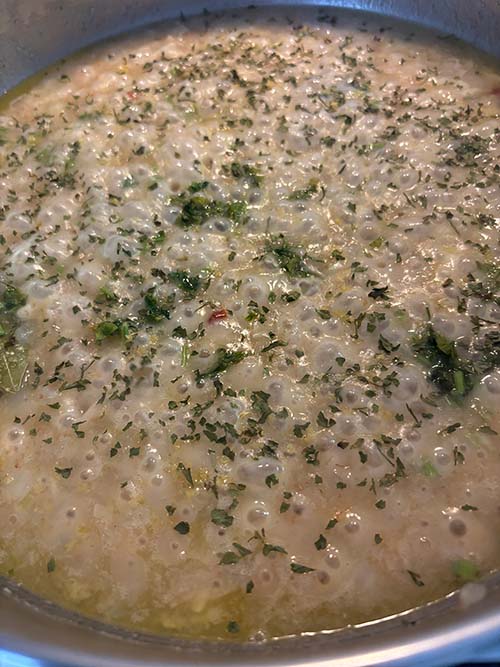 Echando el perejil picado al pochado para la salsa verde
