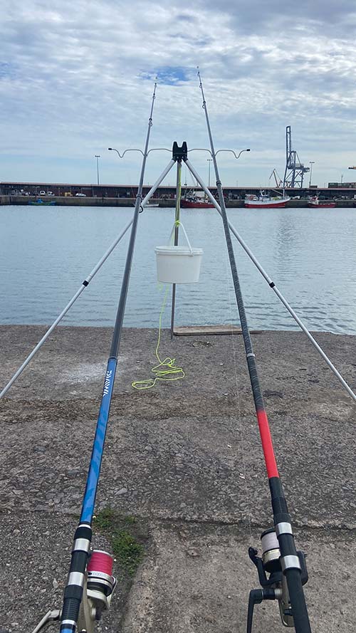 Cañas y carretes robustos para la pesca a fondo en el puerto del Musel en Gijón