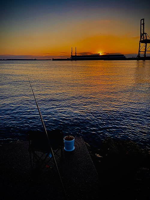 Pescando al amanecer a boya en el puerto del Musel en Gijón