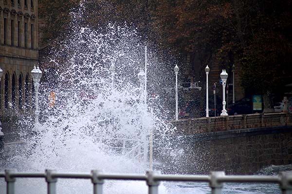 Olas amenazantes saltan en el paseo del muro de San Lorenzo en Gijón