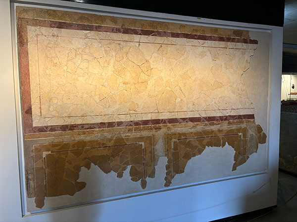 Restos de pinturas murales expuestas en las vitrinas del museo de las termas romanas de Gijón