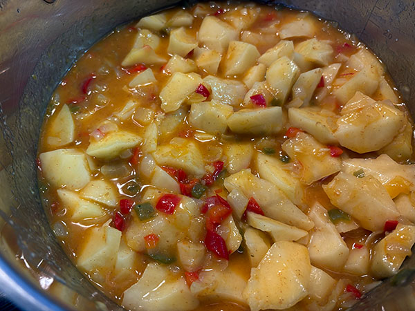 Añadiendo las patatas al guiso de pulpo de pedrero con patatinas