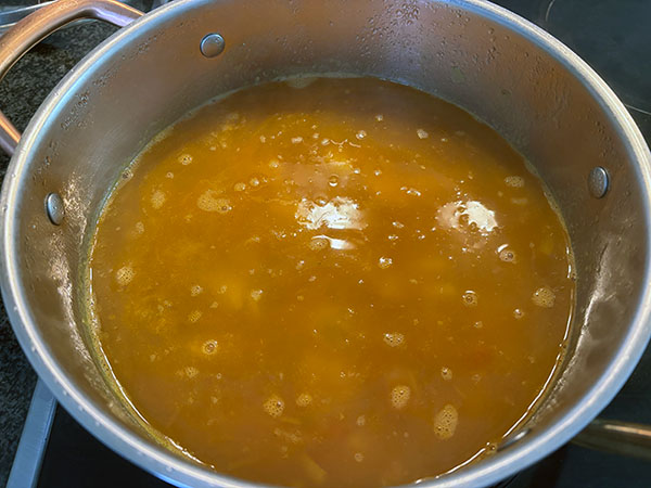 Añadiendo el caldo al guiso de pulpo de pedrero con patatinas
