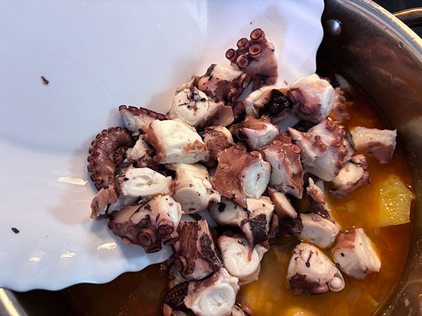Añadiendo el pulpo al guiso del pulpo de pedrero con patatinas
