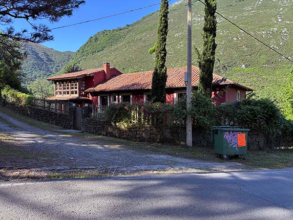 Casa granate con muro de piedra en Pie de Potro donde comienza la senda que te lleva al hayedo de la Biescona en la cordillera del Sueve en Asturias