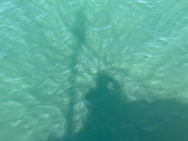 Sombra reflejada en el agua del mar