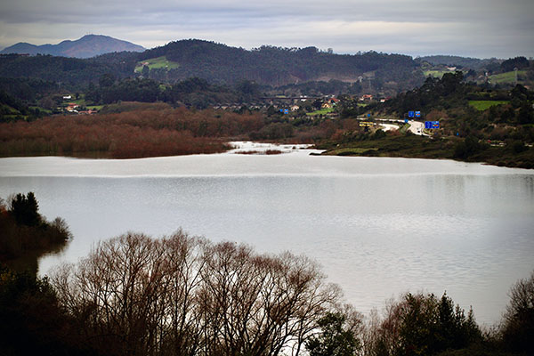Vista del embalse de San Andrés de los tacones en Asturias, con la autopista "Y" al fondo
