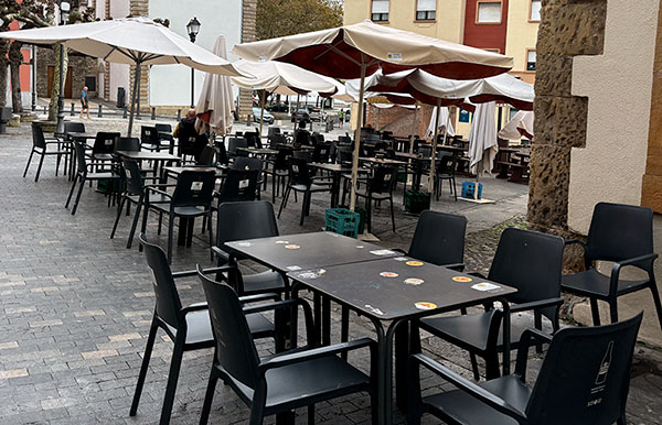 Terraza hostelera en el puerto de un pueblo marinero de Asturias