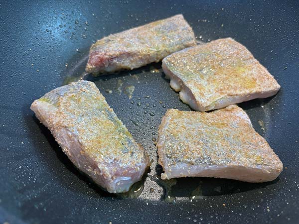 Sellando la merluza para prepararla a la sidra al estilo asturiano