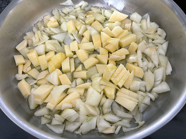 Pochando cebolla, ajo y manzana para la merluza a la sidra al estilo asturiano