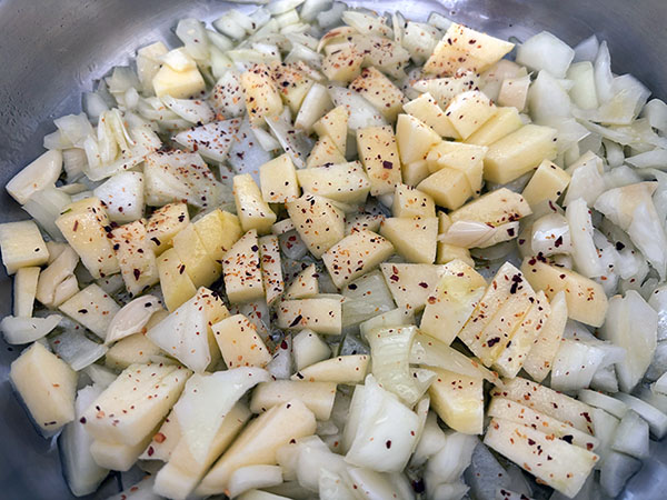 Pochando cebolla, ajo y manzana para la merluza a la sidra al estilo asturiano