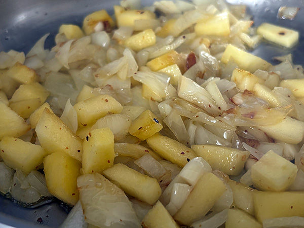Pochando cebolla, ajo y manzana para la merluza a la sidra al estilo asturiano