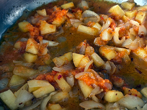 Pochando cebolla, ajo y manzana para la merluza a la sidra al estilo asturiano
