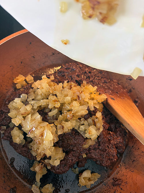 Incorporando la cebolla caramelizada a la morcilla para el torto