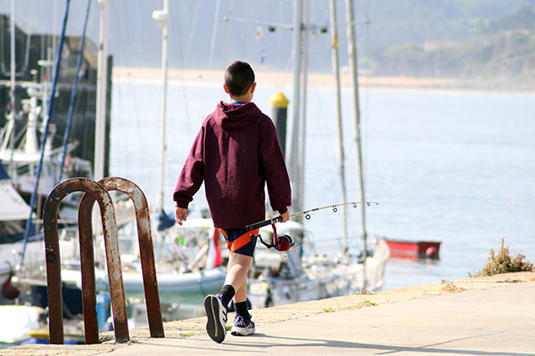 Niño pescando en el puerto de Lastres en Asturias