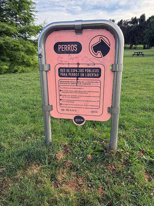 Cartel anunciador de espacio público para perros en libertad en el parque de Los Pericones en Gijón